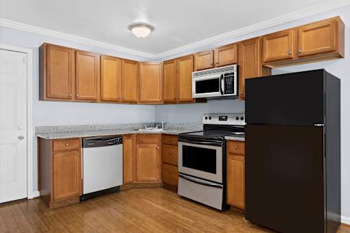 a kitchen with wood cabinets and black appliances